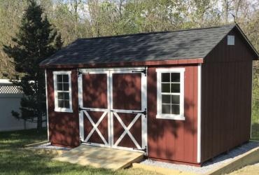 A-frame shed with T1-11 siding painted red with white trim