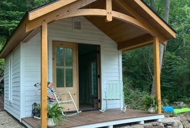 A front porch view of a custom cottage in the heritage cabin style.