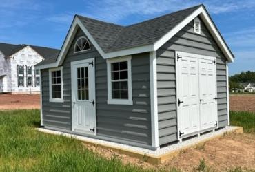 grey-blue victorian style shed. photo taken from at a side angle.