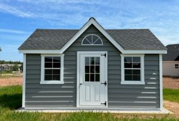 grey-blue victorian style shed. photo taken from the front.