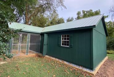 dark green shed with chicken coop.