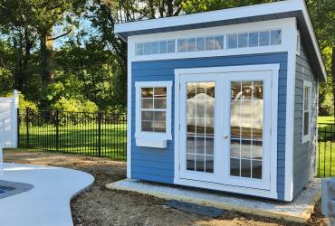 Backyard Studio Shed in Light Blue next to pool.