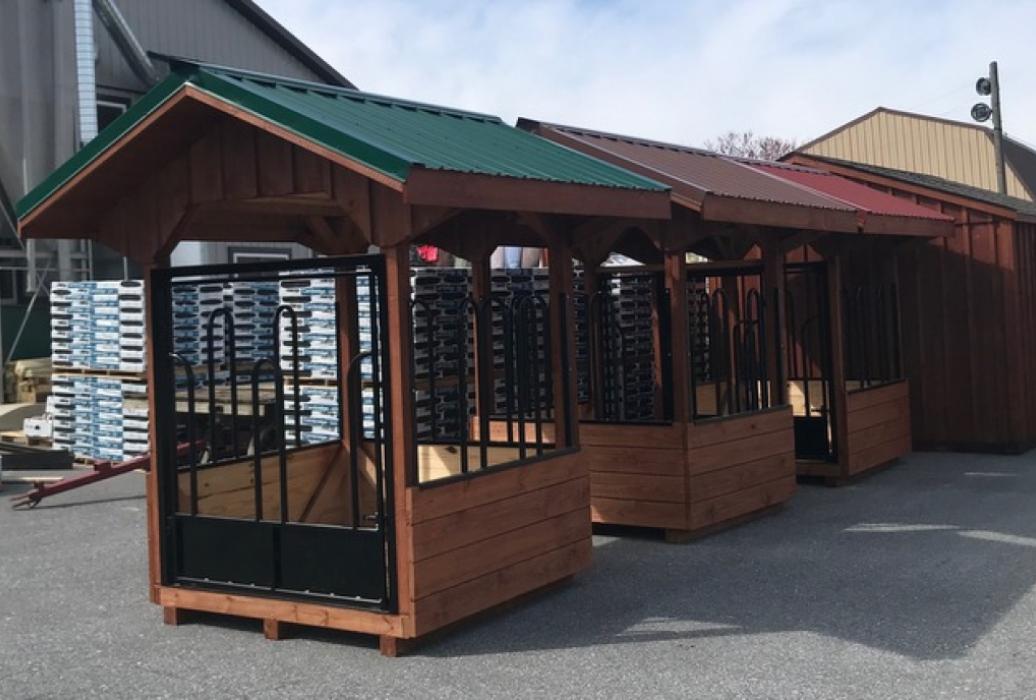 Group of hay bale feeders with metal roofs