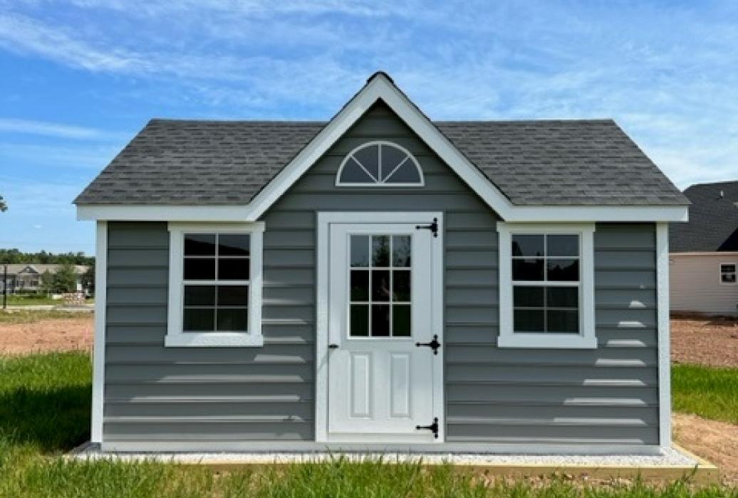 grey-blue victorian style shed. photo taken from the front.