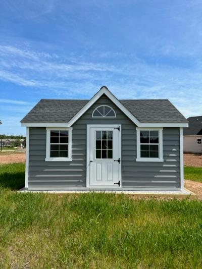 grey-blue victorian style shed. photo taken from the front.