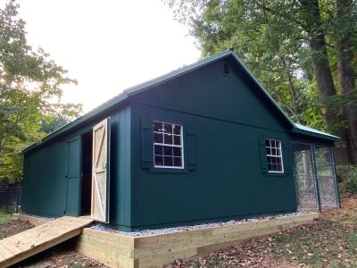 side view of dark green shed with double door. here there are 2 windows.